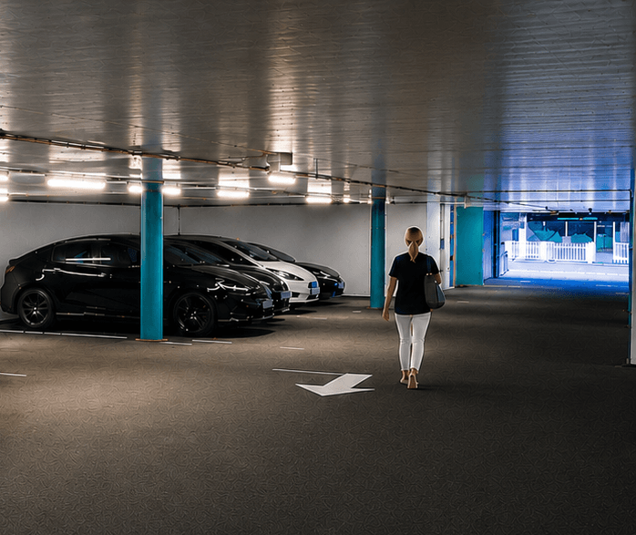 Ansatt går mot bilen i parkeringsanlegget ved Haukeland